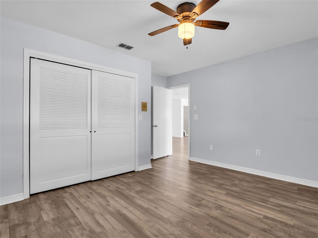 6241 Bayside Drive New Port Richey, FL 34652 - Photo 40 of 78 an empty room with wooden floor closet and fan