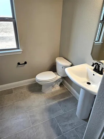 a bathroom with a sink a toilet and a mirror