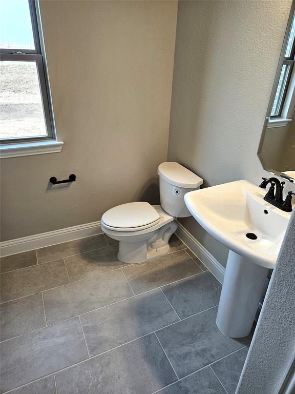 1429 Enloe Road Howe, TX 75459 - Photo 12 of 19 a bathroom with a sink a toilet and a mirror