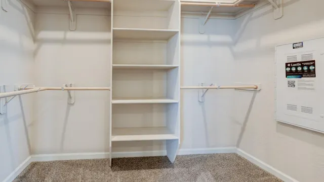 a view of walk in closet with empty racks