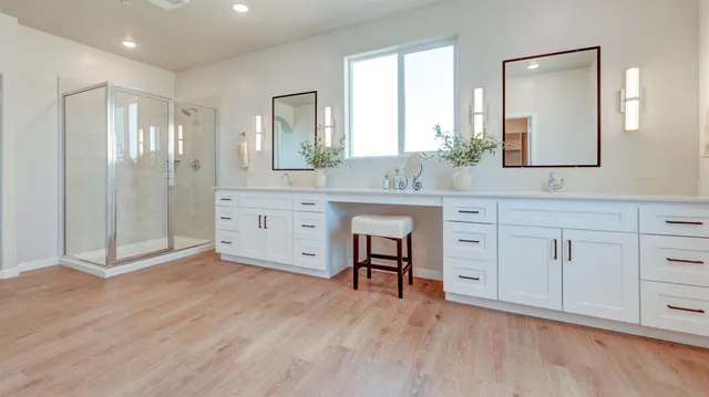 a spacious bathroom with a granite countertop sink mirror and shower