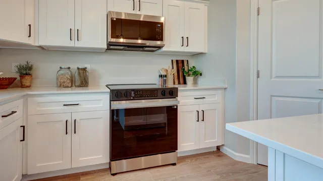 a kitchen with white cabinets and stainless steel appliances