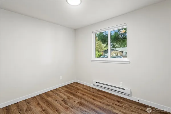 a view of a room with wooden floor and a window