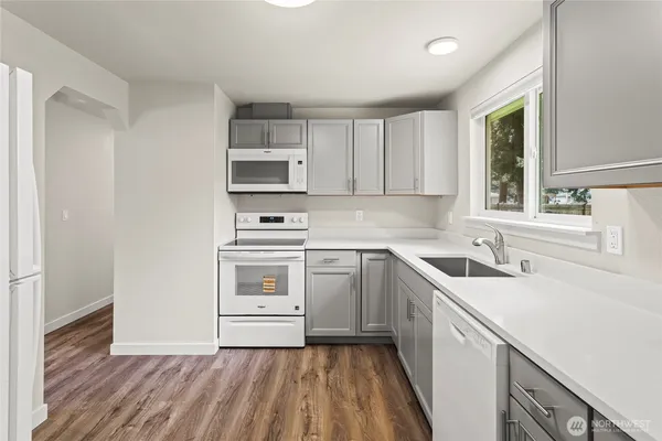 a kitchen with a sink cabinets stainless steel appliances and a window