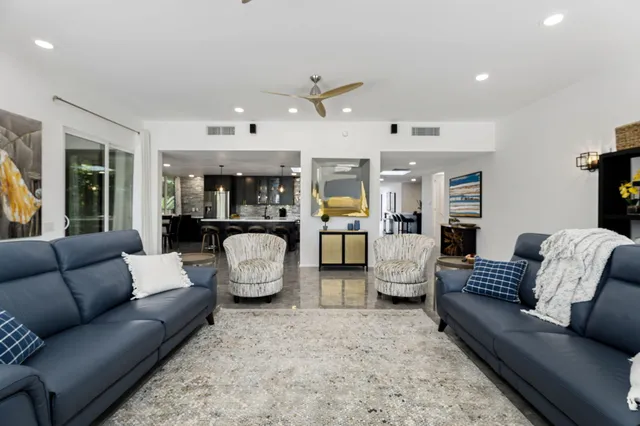 a living room with furniture kitchen view and a table