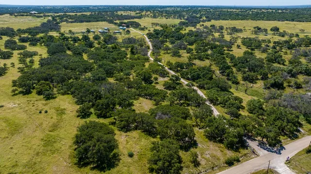 an aerial view of residential houses with outdoor space and trees