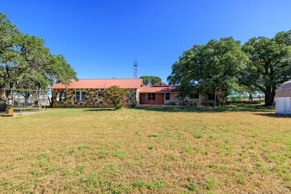 a front view of a building with large trees