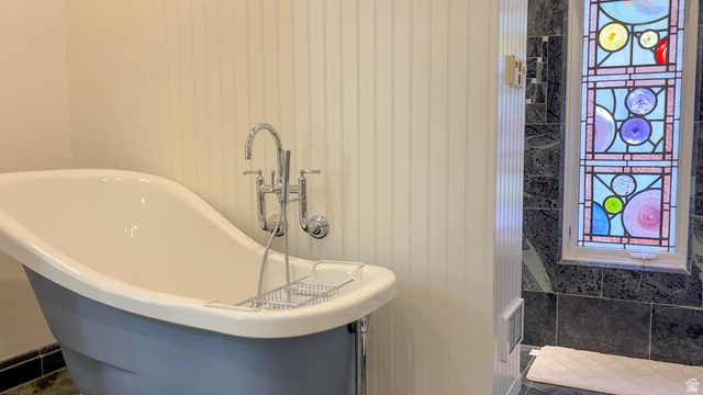 426 West Center Street Parowan, UT 84761 - Photo 29 of 107 Freestanding bathtub with chrome fixtures, beadboard wall paneling, and a stained glass window