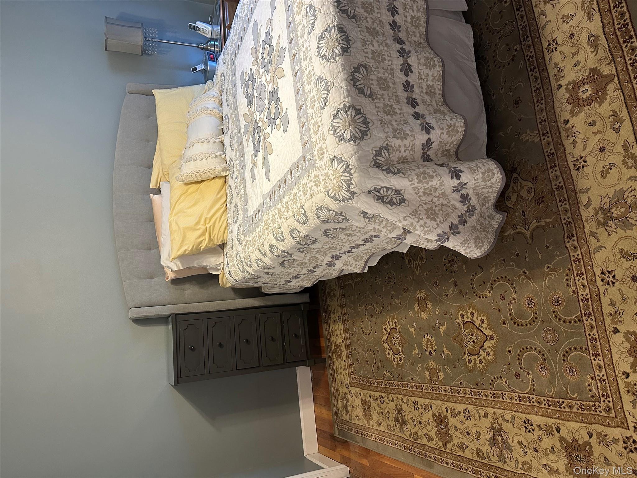 81-49 268th Street, Unit 290B Queens, NY 11004 - Photo 7 of 9 a bed sitting in a bedroom next to a cabinet