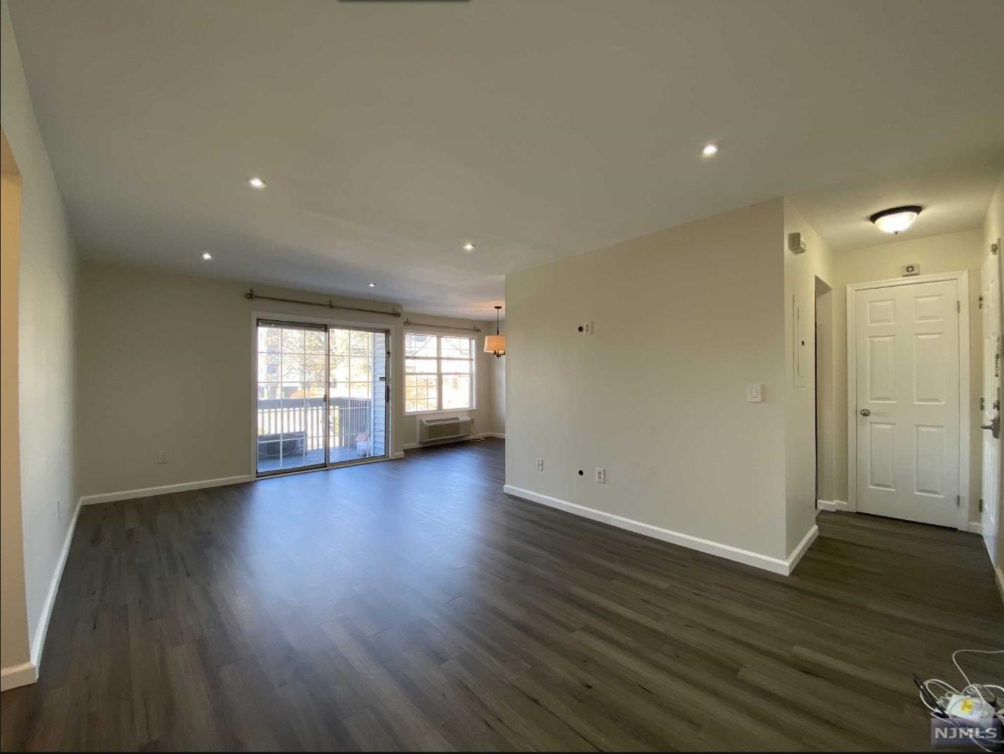 280 Kipp Street, Unit 2A Hackensack, NJ 07601 - Photo 3 of 12 an empty room with wooden floor and windows