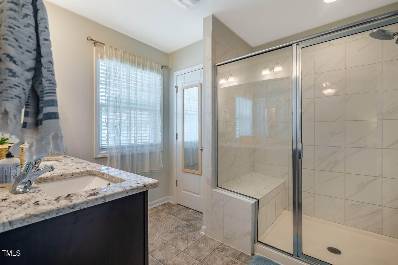 1101 Compass Drive Durham, NC 27713 - Photo 18 of 32 a bathroom with a granite countertop sink a shower and a mirror