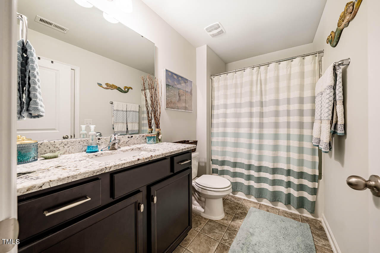1101 Compass Drive Durham, NC 27713 - Photo 19 of 32 a bathroom with a granite countertop sink toilet a mirror and shower curtain