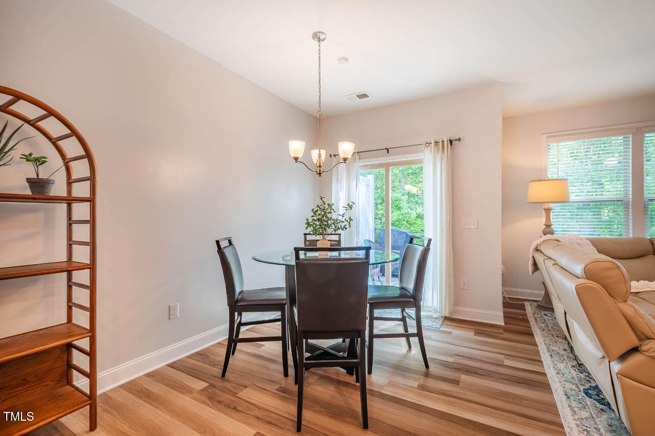 1101 Compass Drive Durham, NC 27713 - Photo 5 of 32 a dining room with furniture a chandelier and wooden floor