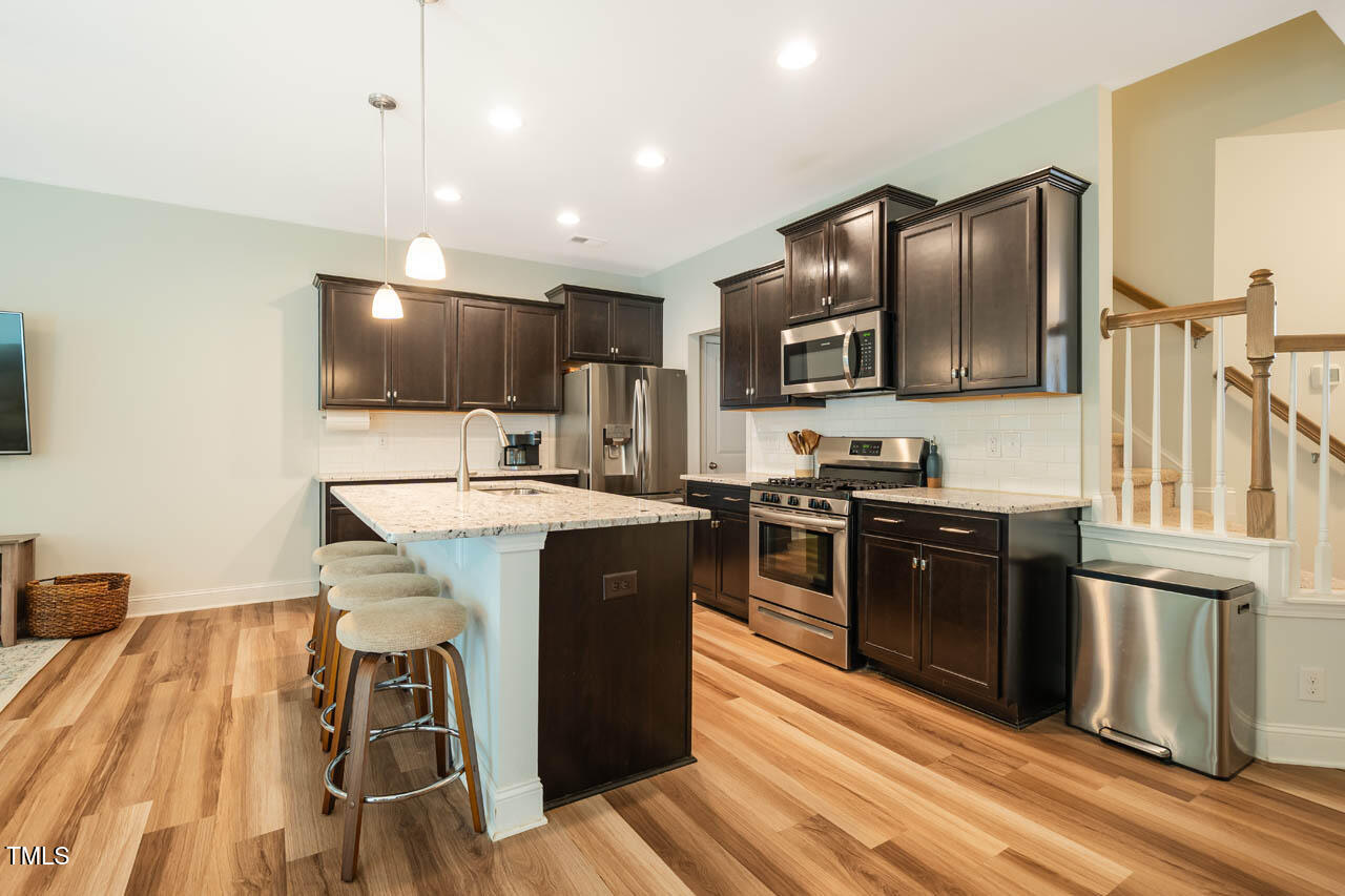 1101 Compass Drive Durham, NC 27713 - Photo 9 of 32 a kitchen with stainless steel appliances granite countertop a stove refrigerator and microwave