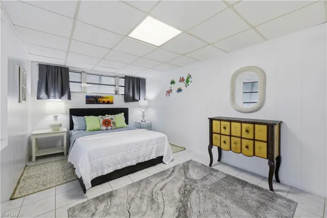 a bedroom with a bed a mirror and dresser