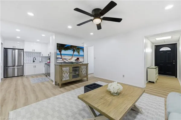 a living room with stainless steel appliances kitchen island furniture and a view of kitchen