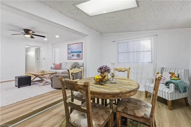 a view of a dining room and livingroom with furniture wooden floor a rug and a chandelier