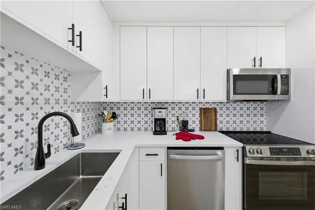 a kitchen with sink a microwave and stove top oven