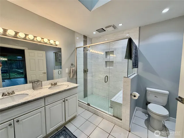 a bathroom with a granite countertop sink toilet and shower