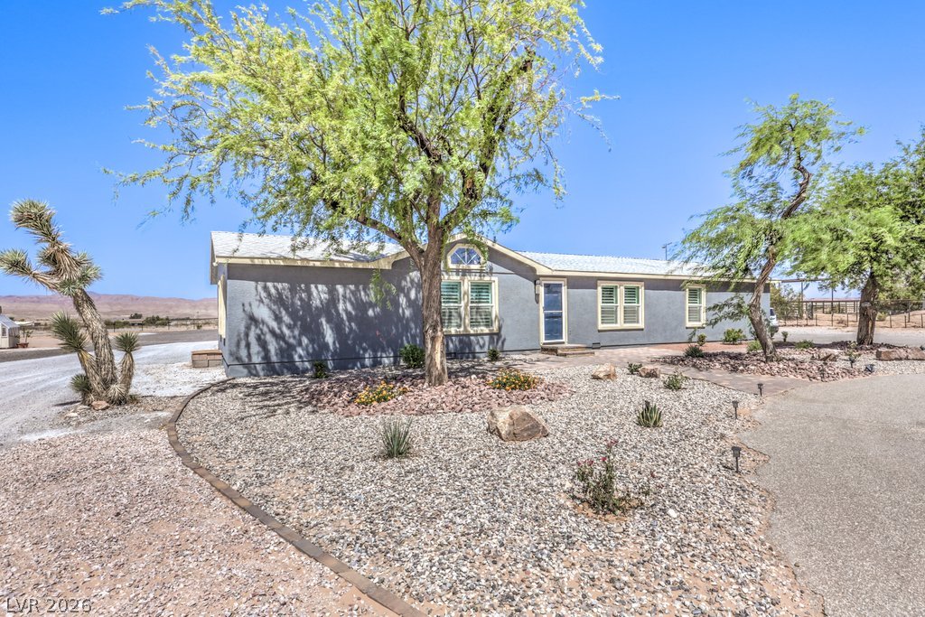 4375 Pinwheel Street Logandale, NV 89021 - Photo 5 of 52 A desert oasis with a grey exterior and drought-tolerant landscaping offers peaceful living.
