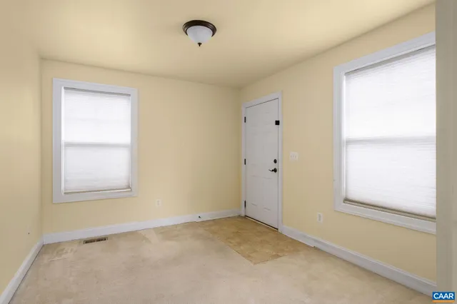an empty room with windows and closet