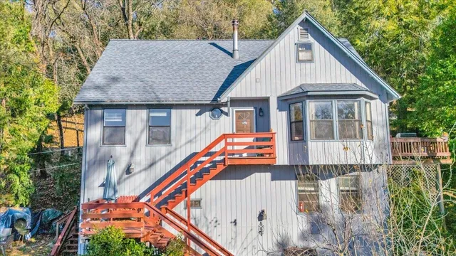 a white house with tall trees in front of it
