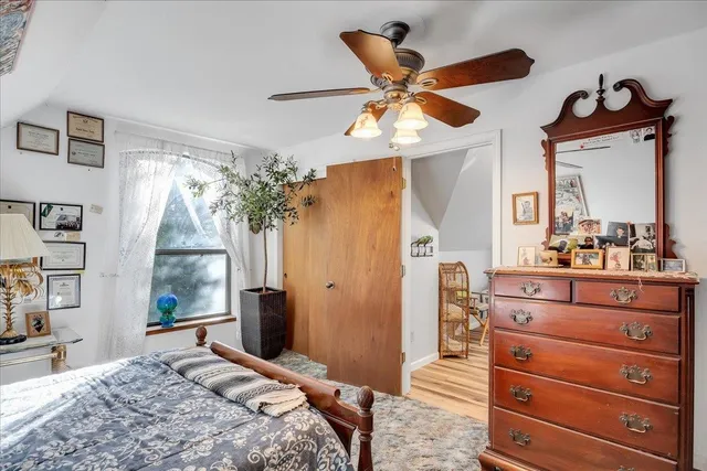 a bedroom with a bed and a mirror on the dresser