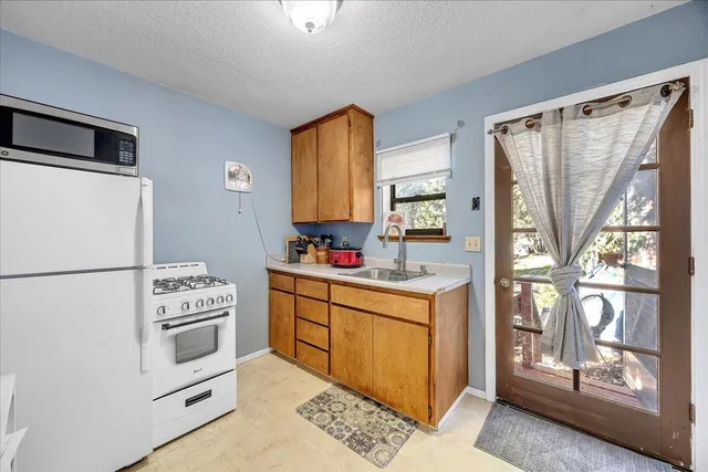 a kitchen with white cabinets and white appliances