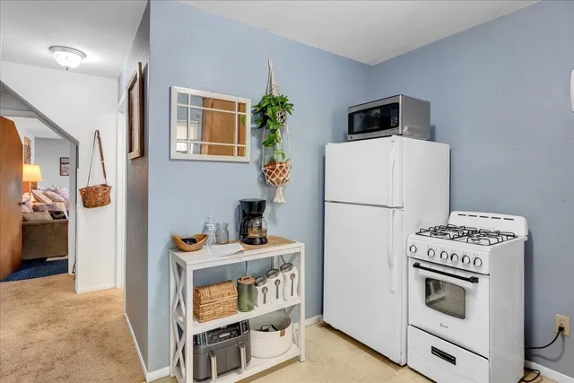 a white refrigerator freezer and a stove sitting inside of a kitchen