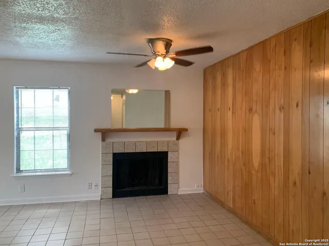 a view of an empty room with window and fireplace