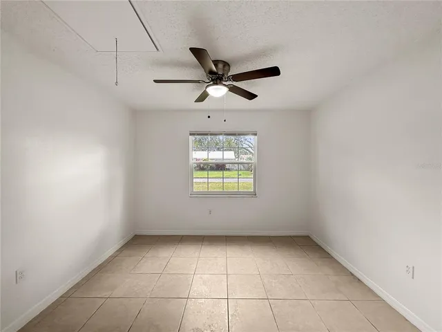 an empty room with a window and a ceiling fan