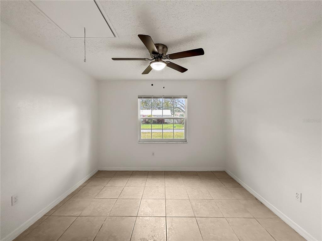 1610 Harbor Way Bartow, FL 33830 - Photo 12 of 25 an empty room with a window and a ceiling fan