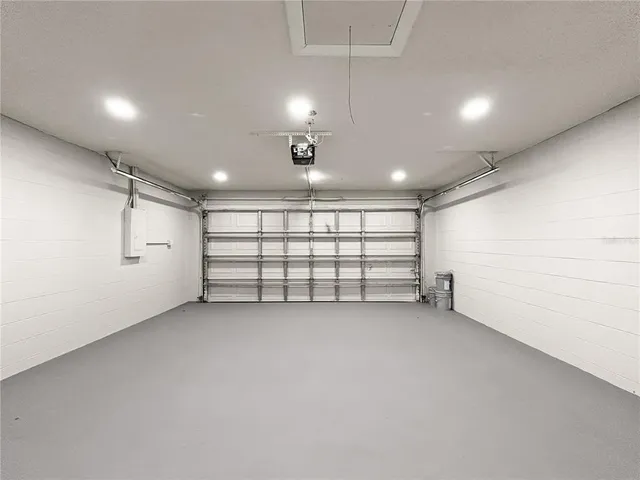 an empty room with white walls and chandelier fan