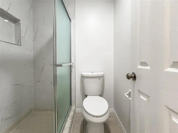 a bathroom with a toilet and a shower