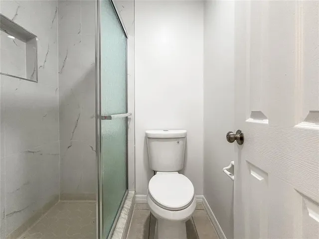 a bathroom with a toilet and a shower