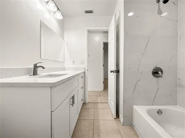 a bathroom with a tub sink and mirror