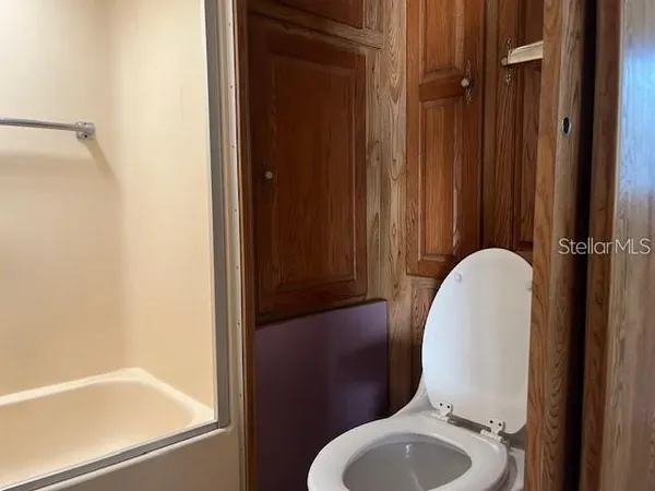 a bathroom with a toilet and a mirror