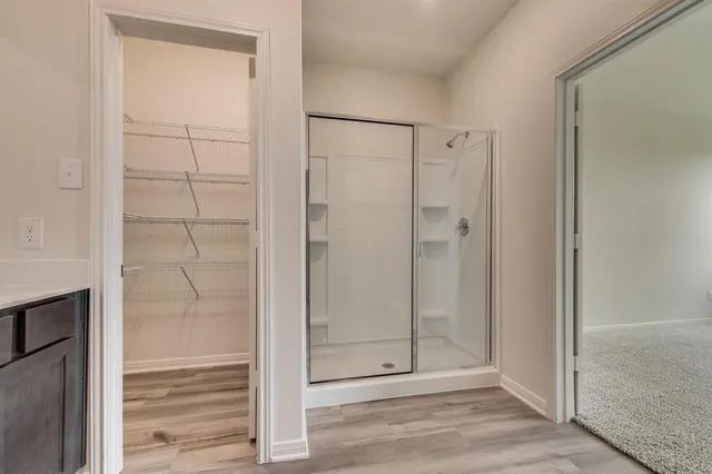 a bathroom with a glass shower door and mirror