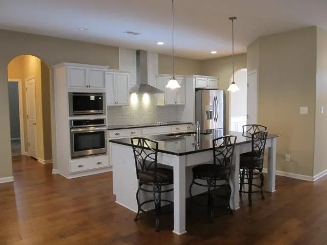 a kitchen with a table chairs microwave and refrigerator