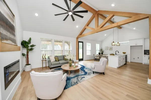 a living room with fireplace furniture and a large window