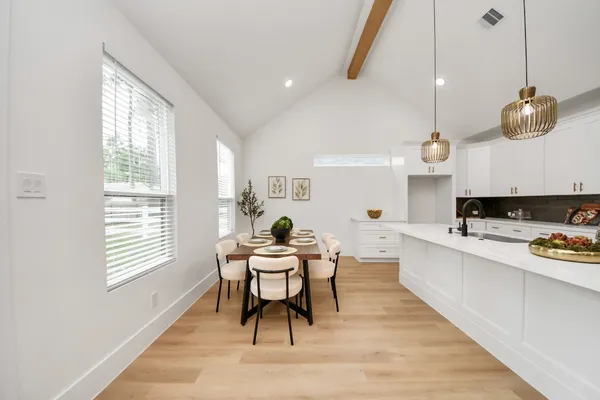 a kitchen with stainless steel appliances white cabinets and wooden floors