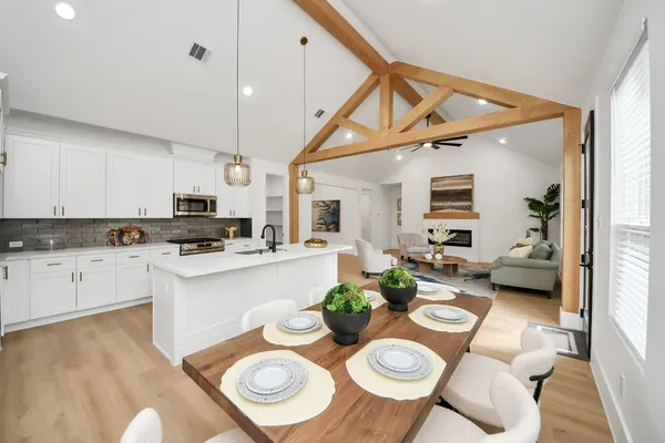 a kitchen with stainless steel appliances kitchen island granite countertop a dining table and chairs