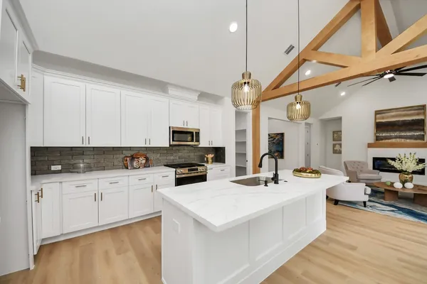 a kitchen with a sink a counter space appliances and cabinets