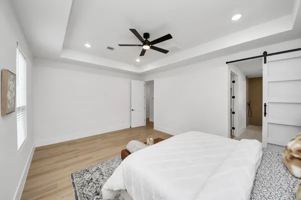 a bedroom with a bed and a ceiling fan