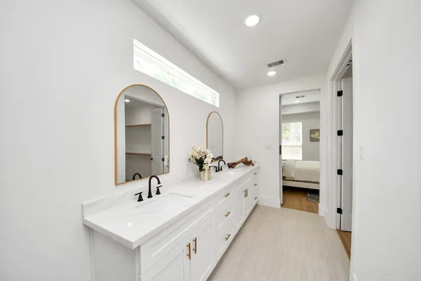 a en suite bathroom with 2 sink mirror and a toilet