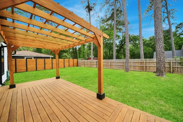 a view of a backyard with wooden floor and fence