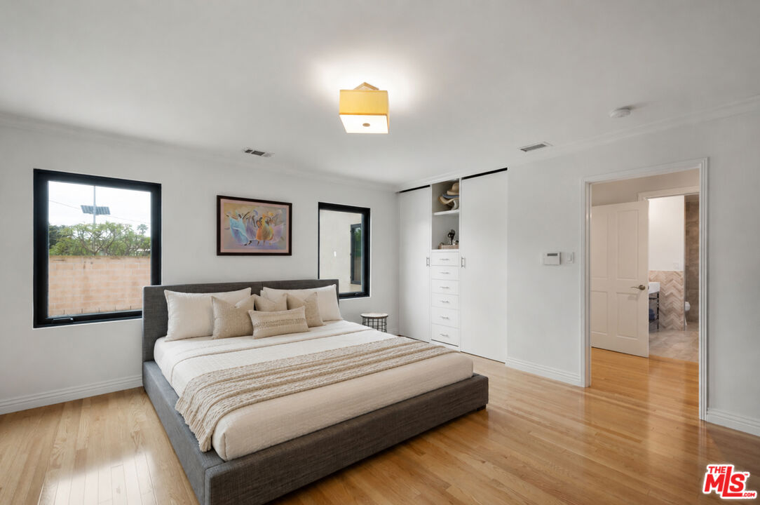 3558 Muirfield Road South Los Angeles, CA 90016 - Photo 26 of 35 a bedroom with a large bed and a painting on the wall