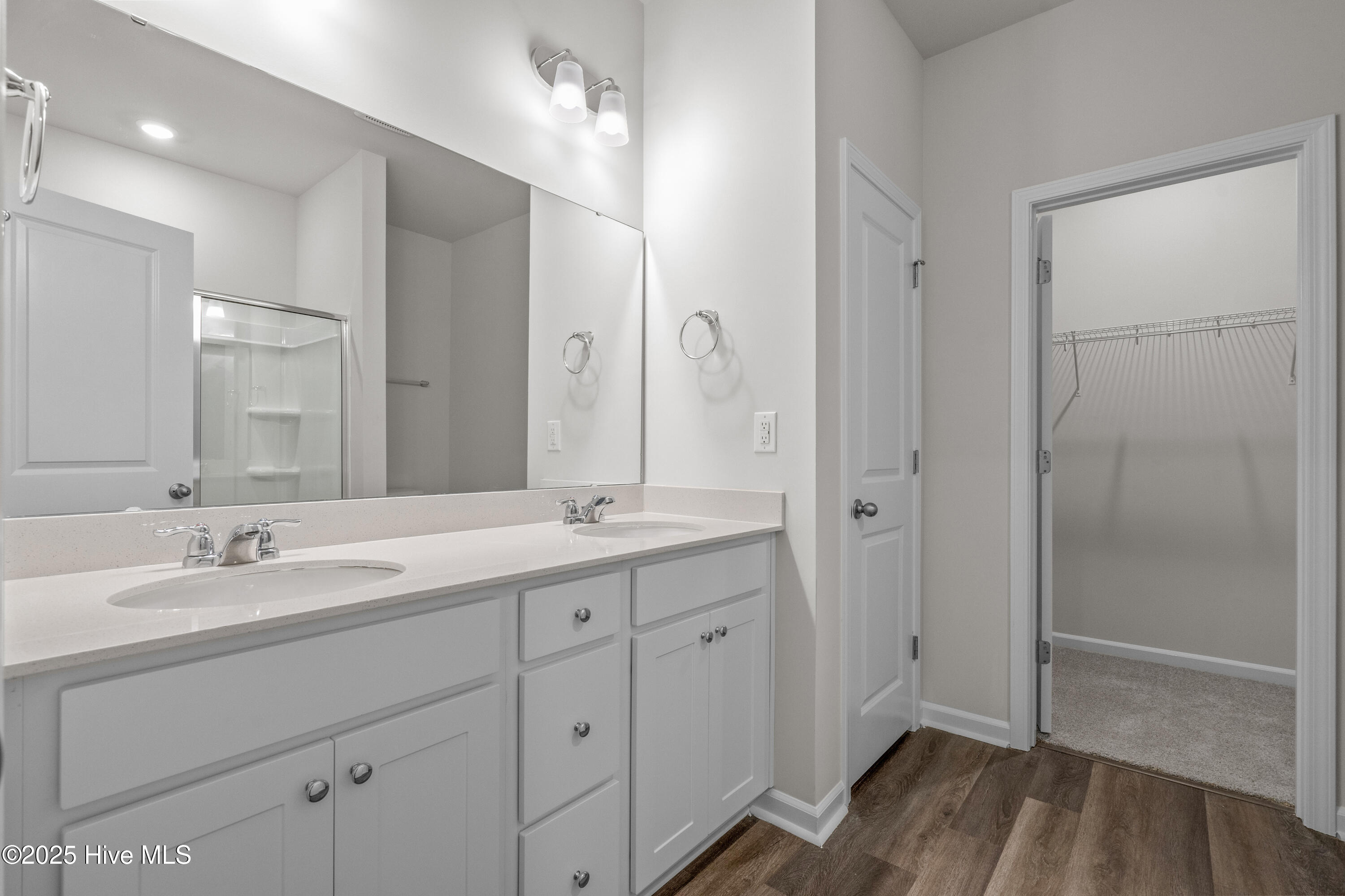 826 Palm Frond Way Calabash, NC 28467 - Photo 13 of 35 Primary sink, linen closet, and walk in closet view white cabinets