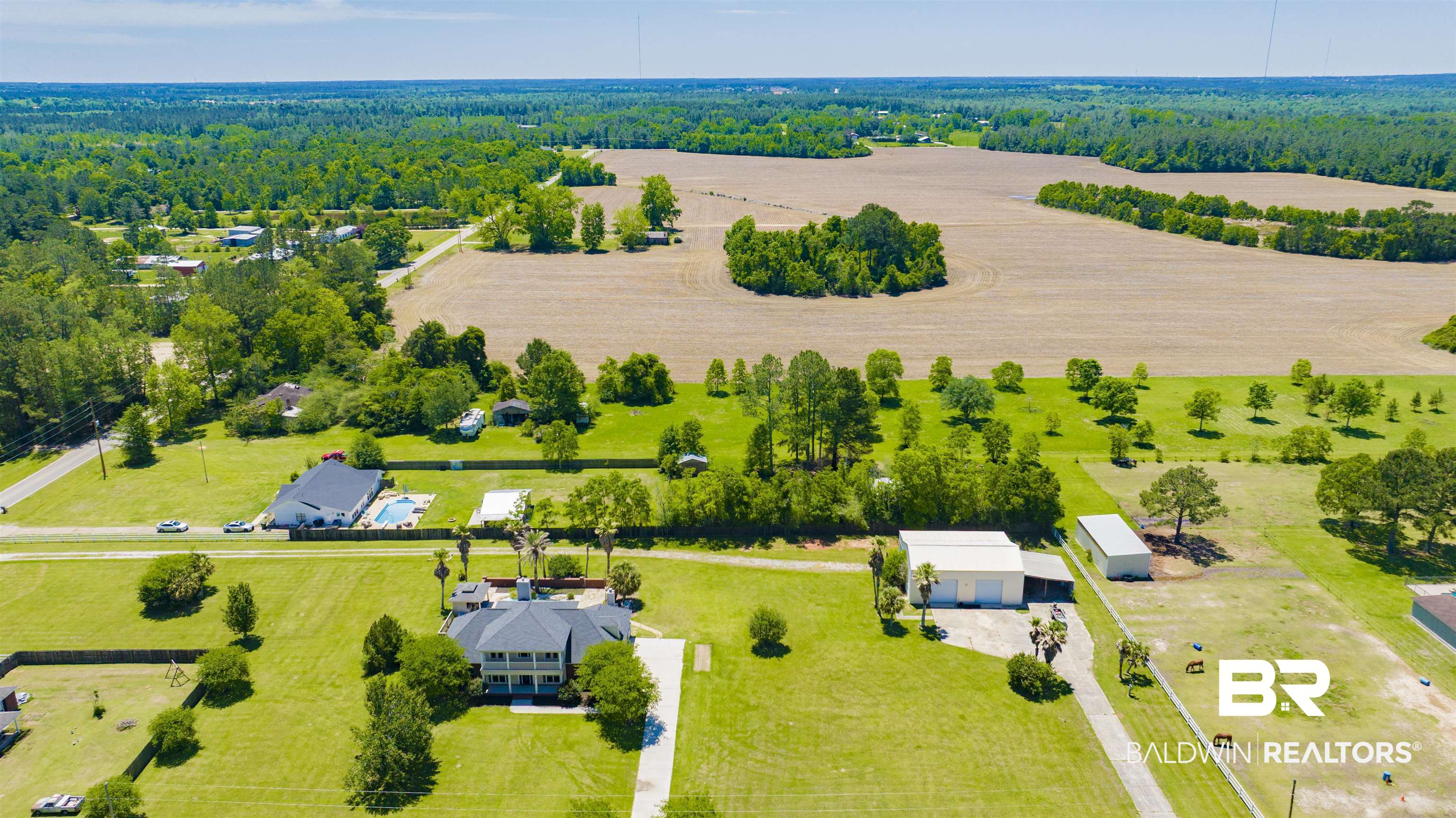 12944 Anna's Way Stapleton, AL 36578 - Photo 7 of 64 Expansive property featuring a large main residence, detached garage structure, additional outbuilding, mature trees, and open land sections