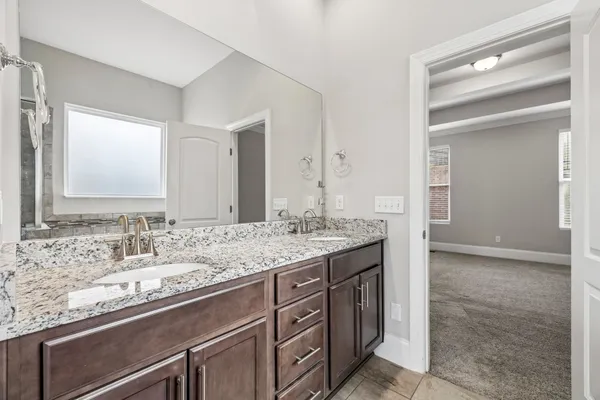 a bathroom with a granite countertop sink and a mirror